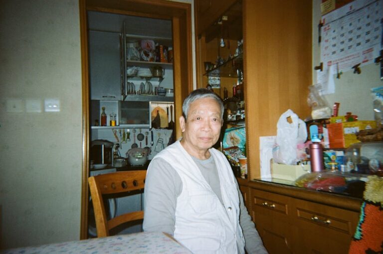 Senior man sitting in a warm, homey kitchen. Casual and relaxed atmosphere.
