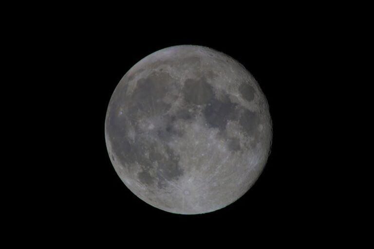 A clear view of a full moon detailing its craters and lunar surface against a black sky.