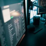 Sleek workspace featuring dual monitors in a dimly lit room, ideal for productivity and tech enthusiasts.