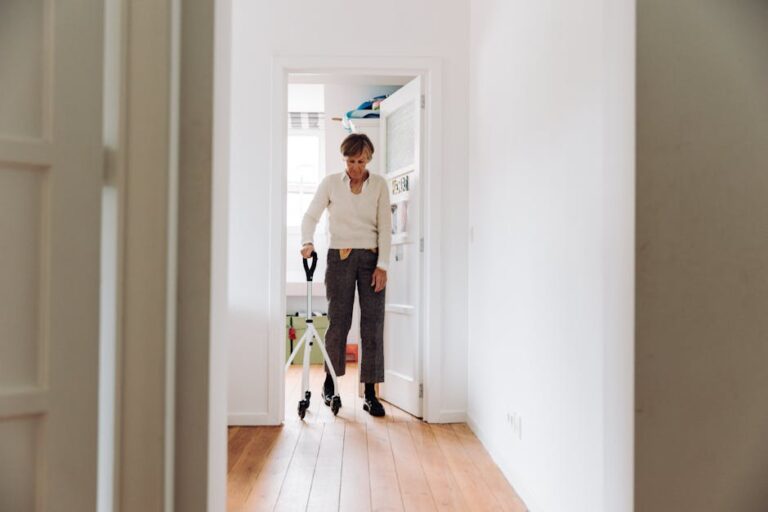 Senior adult using a rollator in a sunlit hallway, emphasizing mobility and independence.