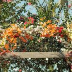 Beautiful wedding arch decorated with vibrant flowers in a tropical setting.