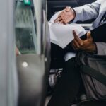 Businessman reviewing documents inside a vehicle, depicting focus and professionalism.