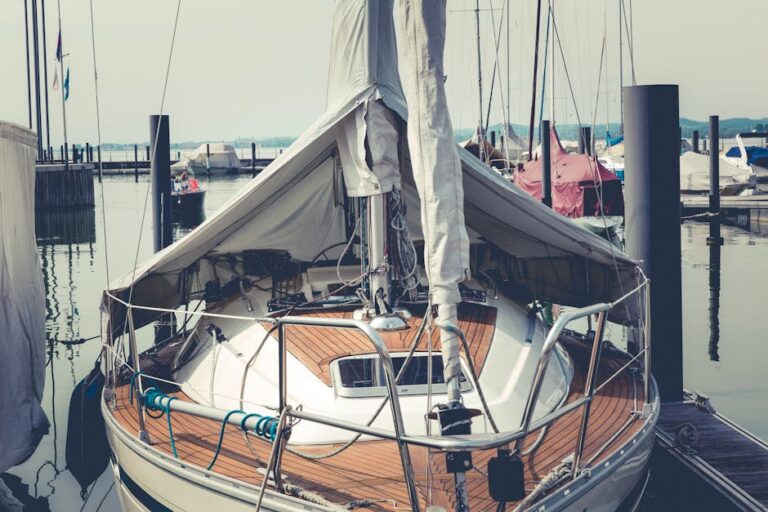 A peaceful scene of a sailboat moored at a harbor with calm waters, offering a tranquil maritime ambiance.
