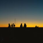 Silhouettes of people against a vibrant sunset on a beach in Bình Thuận, Vietnam.