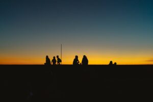 Silhouettes of people against a vibrant sunset on a beach in Bình Thuận, Vietnam.