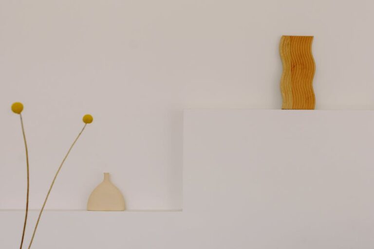 Simple and elegant minimalist decor featuring a wooden sculpture and vase.