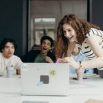 A diverse group of young professionals collaborating enthusiastically in an office setting.
