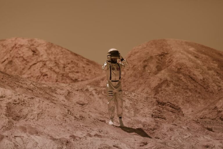 Astronaut in detailed spacesuit explores a Mars-like rocky landscape outdoors, evoking sci-fi adventure.