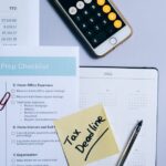 Organized tax preparation setup featuring checklist, calendar, and smartphone calculator for effective planning.