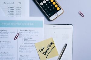 Organized tax preparation setup featuring checklist, calendar, and smartphone calculator for effective planning.