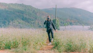 A photographer captures the scenic beauty of a rural flower field in natural daylight.