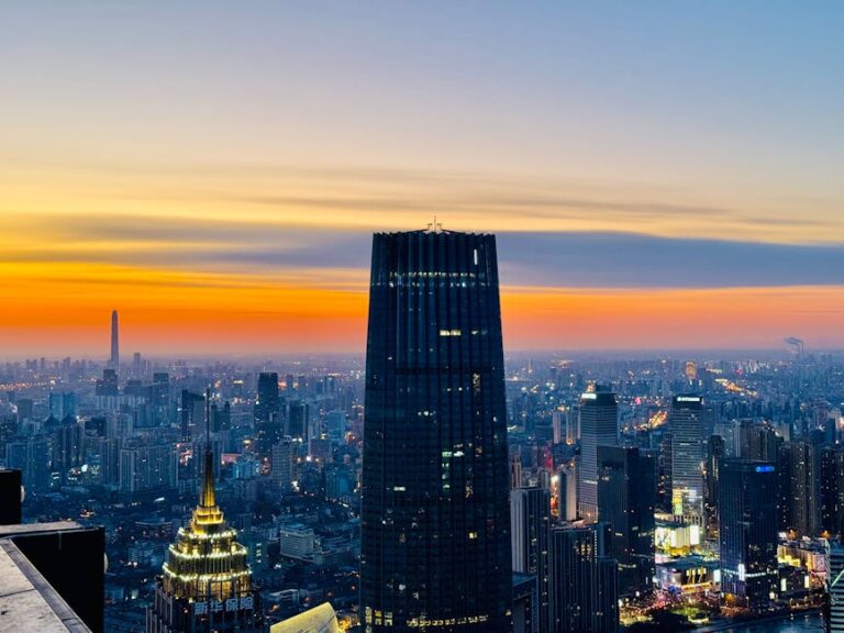 Beautiful city skyline at sunset with modern skyscrapers under a colorful sky.
